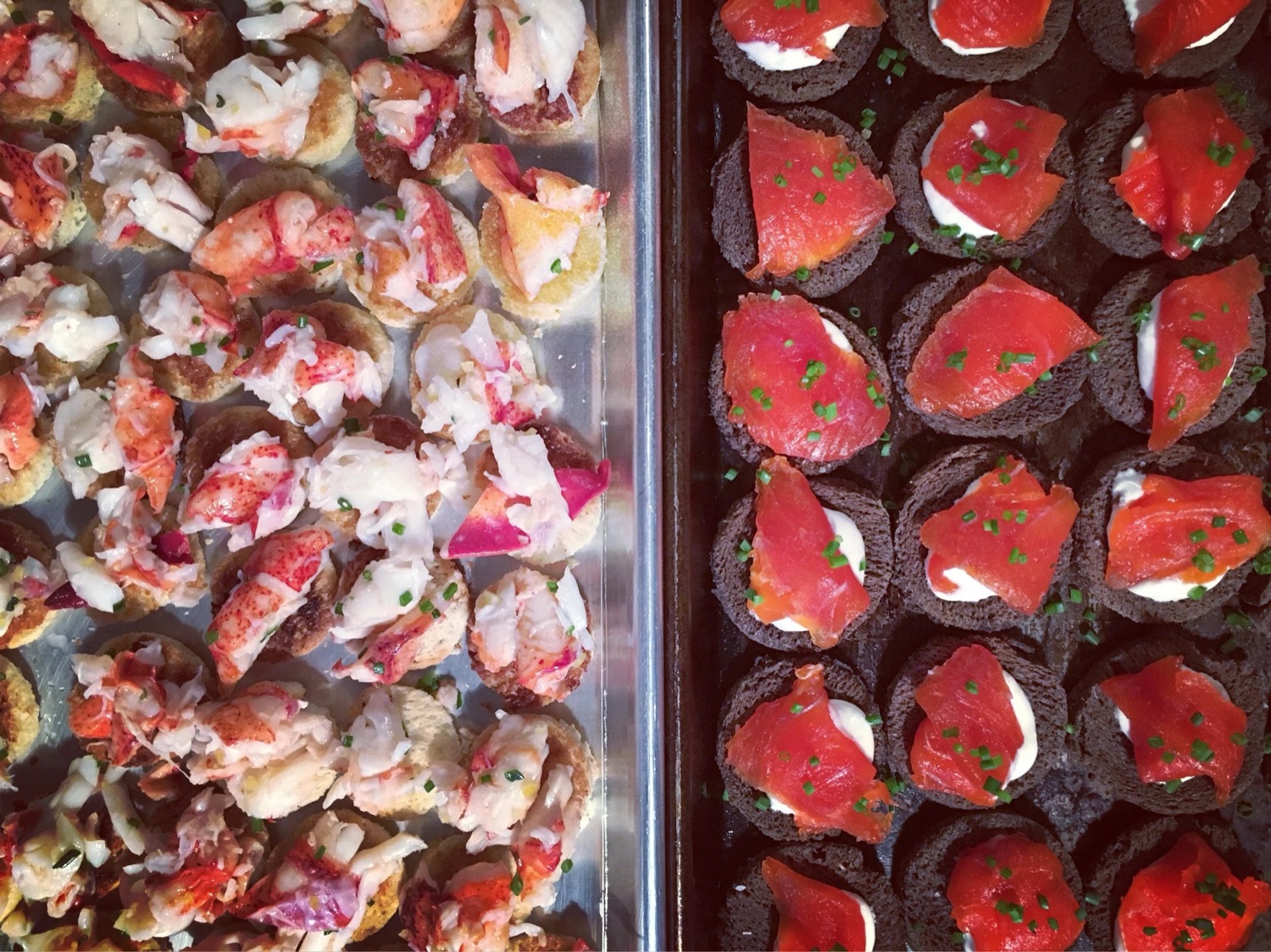 Catering trays of lobster toasts and gravlax on pumpernickel.